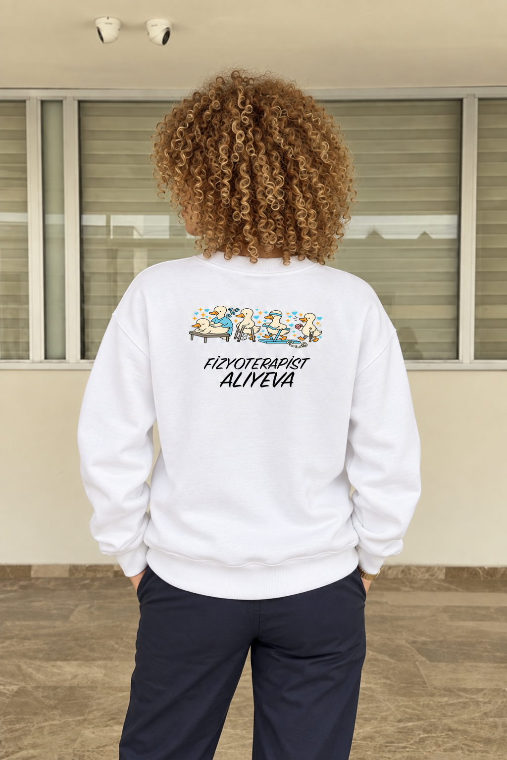 PT-DSG-3827 beyaz Aliyeva sweatshirt; klinikte aynı kişinin arka görünümü, orijinal ördek ve isim baskısıyla